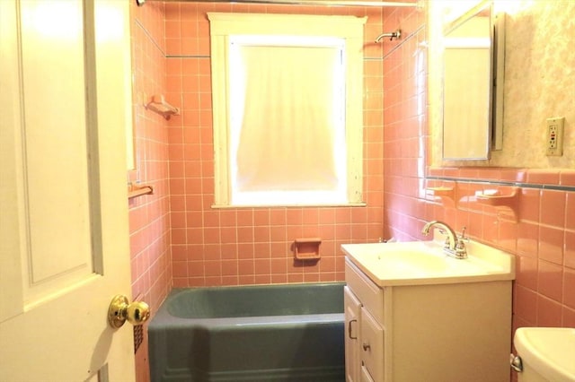 full bathroom featuring shower / bath combination, tile walls, toilet, and vanity