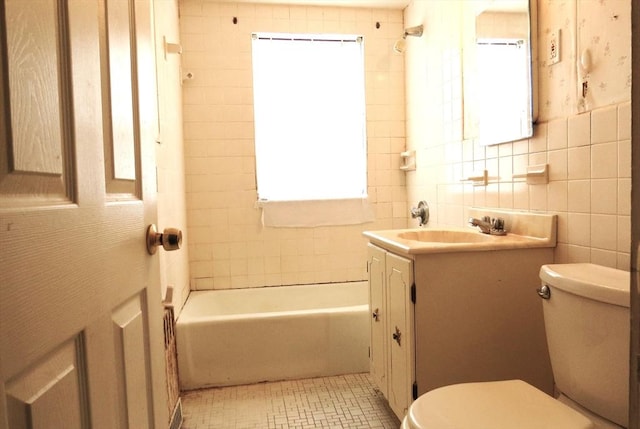 full bath featuring bathtub / shower combination, tile walls, toilet, and vanity