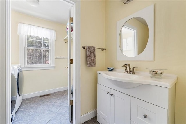 bathroom with vanity, washer / dryer, and tile patterned floors