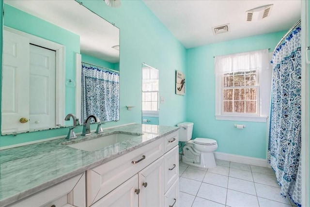 bathroom with vanity, plenty of natural light, tile patterned floors, and toilet