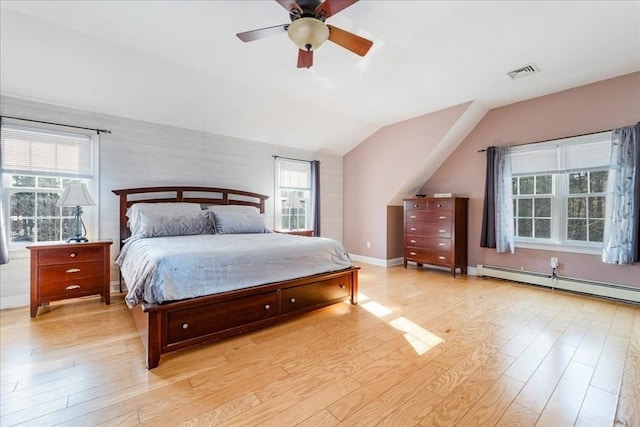 bedroom with multiple windows, a baseboard radiator, and light hardwood / wood-style flooring