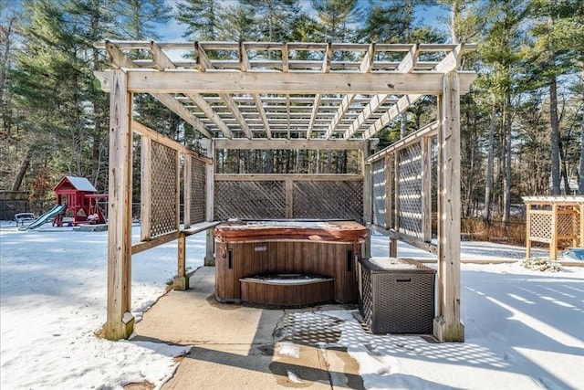 snow covered patio featuring a hot tub, a playground, and a pergola