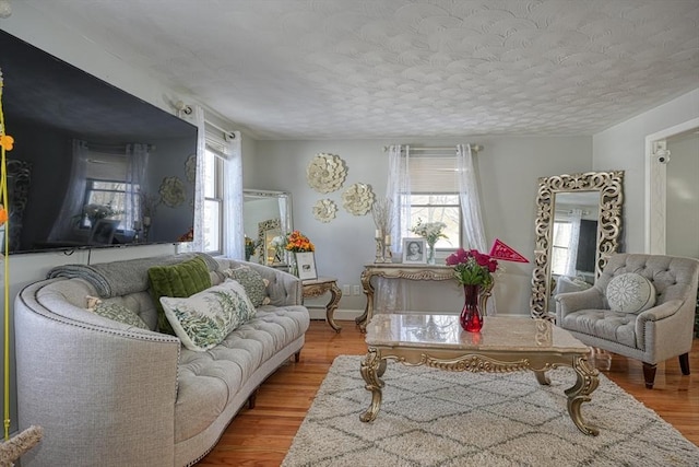 living room featuring plenty of natural light, a textured ceiling, and wood finished floors