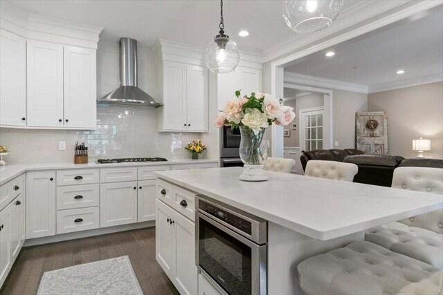 21 Bailey Pond Ln Unit 21, Amesbury, MA 01913 - kitchen featuring wall chimney exhaust hood, black stovetop, backsplash, dark wood finished floors, and a breakfast bar area