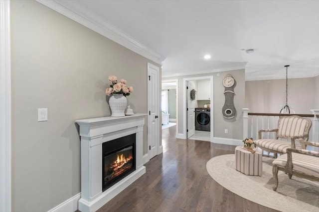 21 Bailey Pond Ln Unit 21, Amesbury, MA 01913 - sitting room featuring washer / dryer, crown molding, a glass covered fireplace, dark wood finished floors, and baseboards