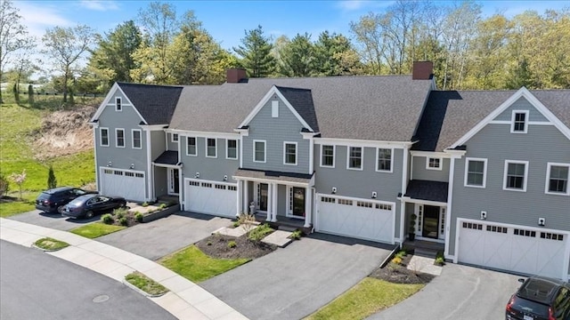 21 Bailey Pond Ln Unit 21, Amesbury, MA 01913 - view of front of property featuring a chimney, an attached garage, a shingled roof, and driveway