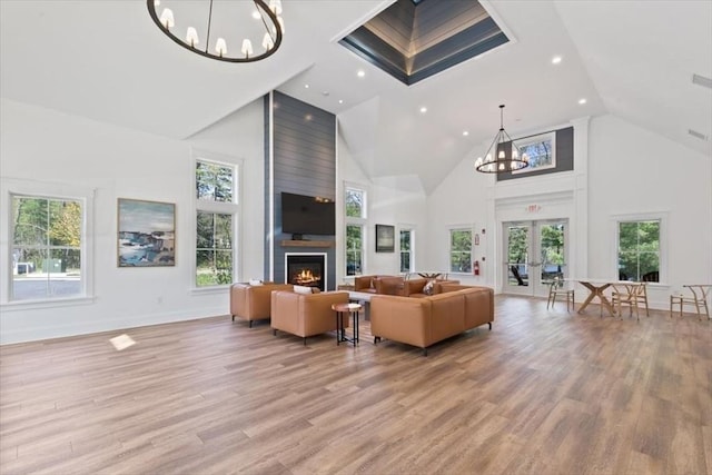 21 Bailey Pond Ln Unit 21, Amesbury, MA 01913 - living room with a chandelier, high vaulted ceiling, a large fireplace, light wood-style flooring, and french doors