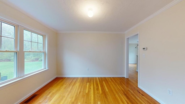 unfurnished room featuring baseboards, light wood-style floors, and ornamental molding