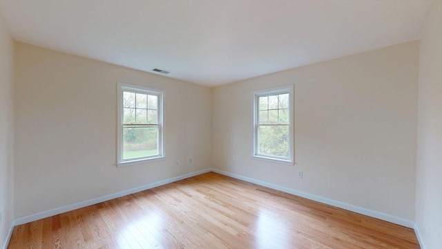 unfurnished room featuring light wood finished floors and baseboards