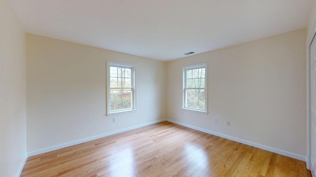 spare room featuring light wood-style floors and baseboards
