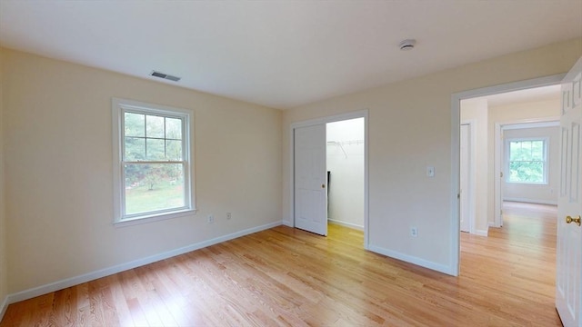 unfurnished room featuring light wood finished floors, baseboards, and a smoke detector