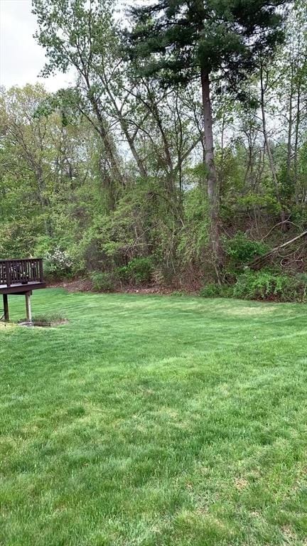view of grassy yard featuring a wooden deck