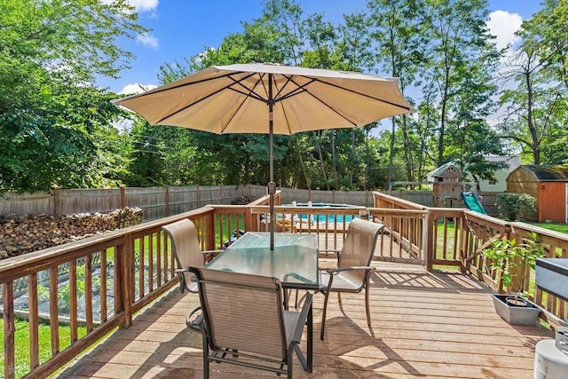 2 Woodbrier Rd, Topsfield, MA 01983 - wooden terrace featuring a fenced backyard, a storage unit, outdoor dining space, an outbuilding, and a playground