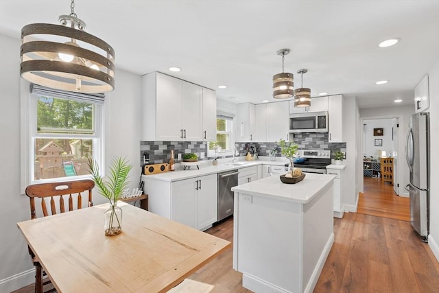 2 Woodbrier Rd, Topsfield, MA 01983 - kitchen with stainless steel appliances, a sink, backsplash, a kitchen island, and white cabinets