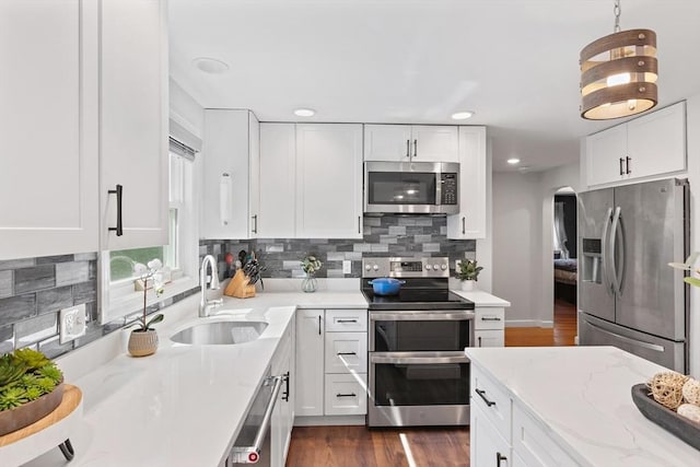 2 Woodbrier Rd, Topsfield, MA 01983 - kitchen featuring stainless steel appliances, a sink, arched walkways, white cabinetry, and recessed lighting
