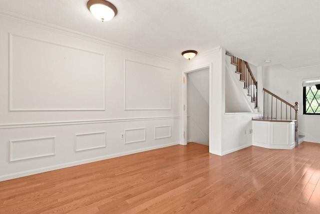 246 Farrwood Dr Unit 246, Haverhill, MA 01835 - unfurnished living room featuring light wood-style floors, a decorative wall, stairway, and ornamental molding