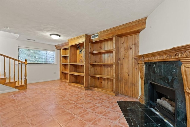 246 Farrwood Dr Unit 246, Haverhill, MA 01835 - living room featuring stairway, a tile fireplace, a textured ceiling, and light tile patterned floors