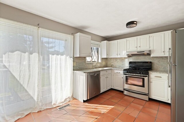 246 Farrwood Dr Unit 246, Haverhill, MA 01835 - kitchen with stainless steel appliances, under cabinet range hood, decorative backsplash, white cabinets, and light tile patterned flooring