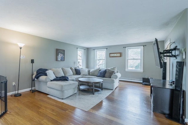 living room featuring wood finished floors, baseboards, and baseboard heating