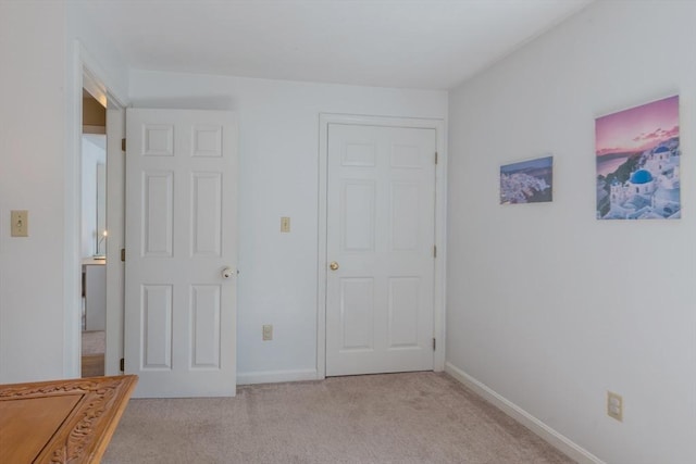 bedroom with light carpet and baseboards