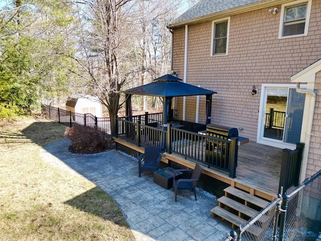 exterior space with a patio area, a deck, and roof with shingles