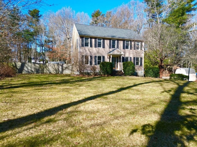 colonial inspired home featuring a front yard and fence