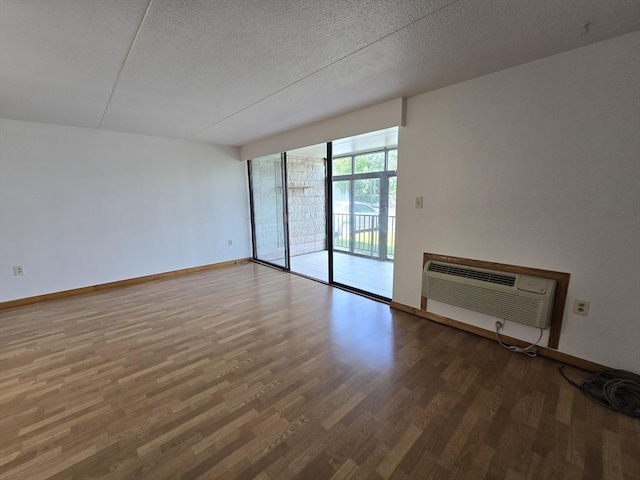 17 Skyline Dr Unit 3, Braintree, MA 02184 - unfurnished living room featuring a wall mounted AC, wood finished floors, and a textured ceiling