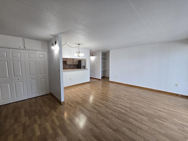 17 Skyline Dr Unit 3, Braintree, MA 02184 - unfurnished living room with wood finished floors, a textured ceiling, and a chandelier