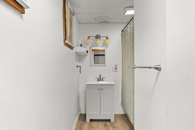 bathroom with baseboards, wood finished floors, and vanity