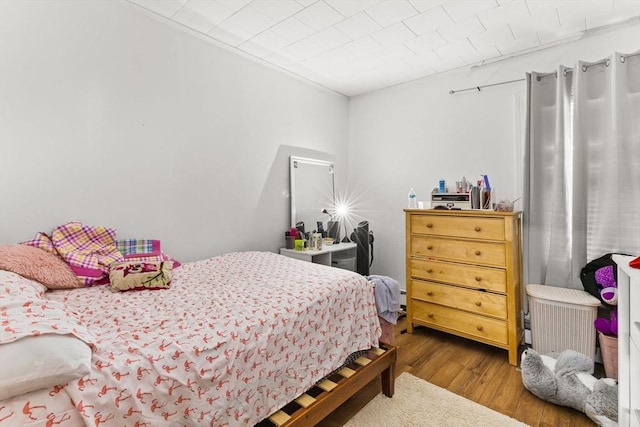 bedroom with crown molding and wood finished floors