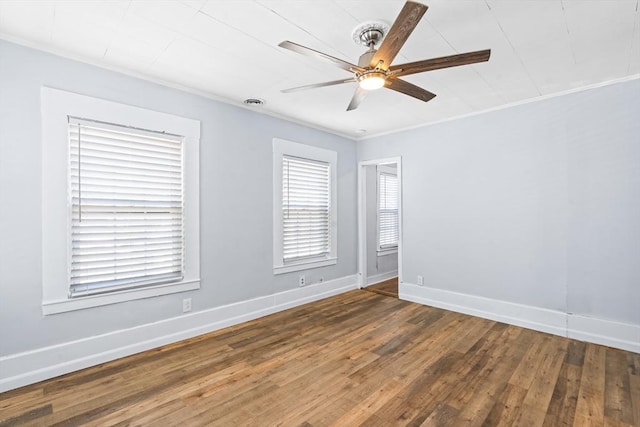 unfurnished room featuring baseboards, dark wood finished floors, a ceiling fan, and crown molding