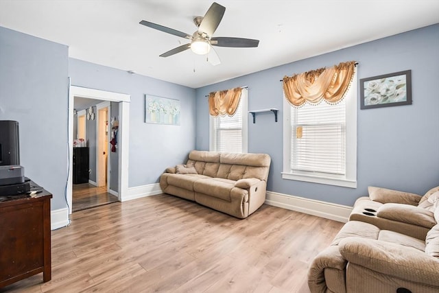 living room featuring a ceiling fan, light wood-type flooring, and baseboards