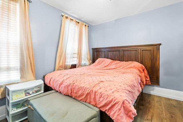 bedroom featuring baseboards and wood finished floors