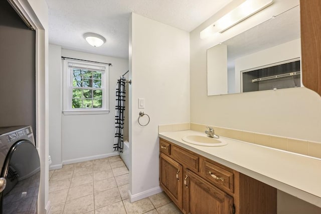 523 Washington St Unit A9, Pembroke, MA 02359 - bathroom featuring washer / dryer, vanity, shower / tub combo with curtain, tile patterned flooring, and a textured ceiling
