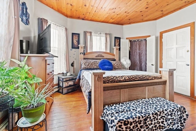 bedroom featuring crown molding and light wood finished floors