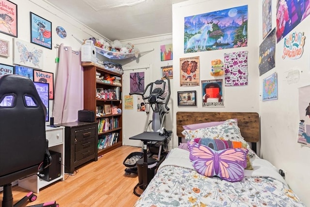 bedroom featuring crown molding and wood finished floors