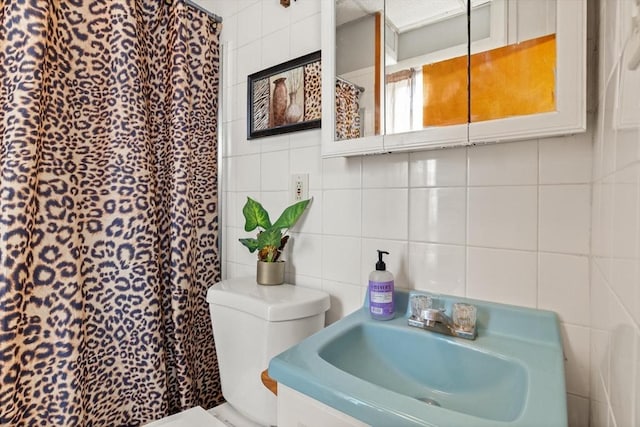 bathroom featuring tasteful backsplash, toilet, curtained shower, a sink, and tile walls