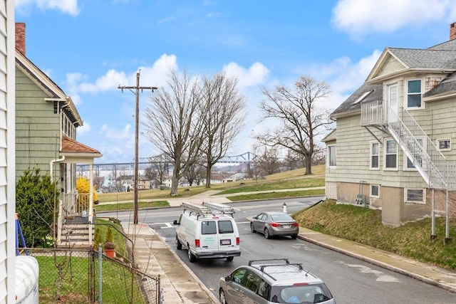 view of road with curbs, a gate, and sidewalks