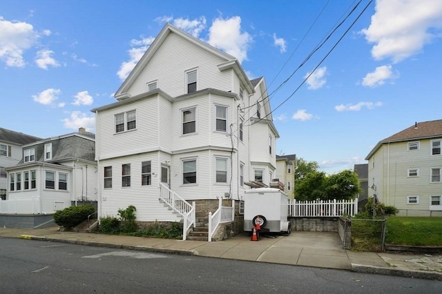 view of front facade with a residential view and fence
