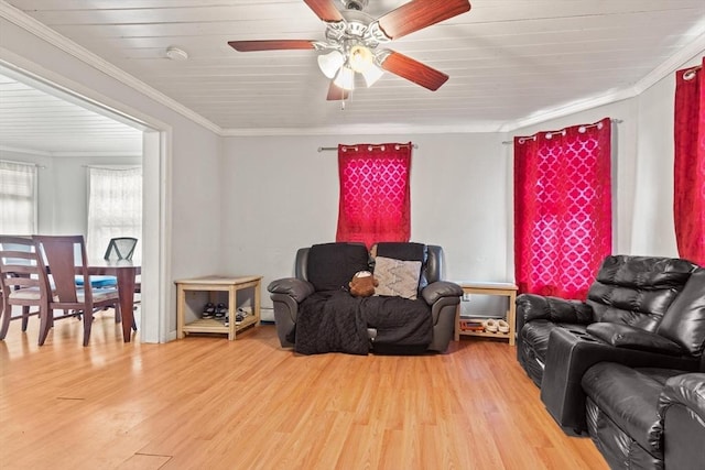 living room with ornamental molding, a ceiling fan, a baseboard heating unit, and wood finished floors