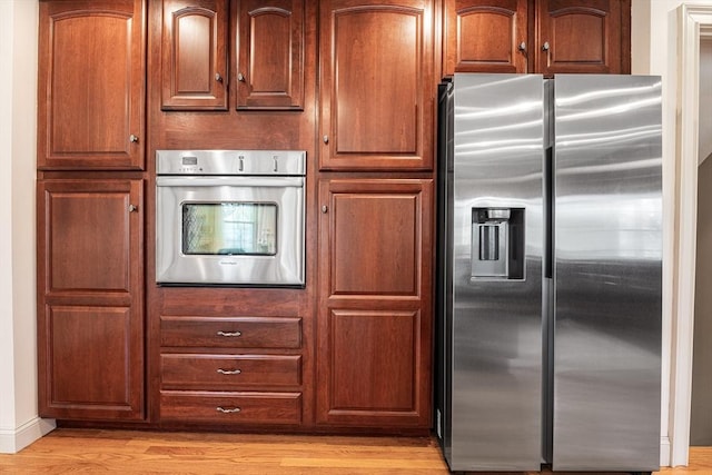 kitchen featuring brown cabinets, stainless steel appliances, and light wood-type flooring