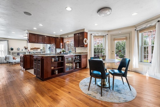 dining room featuring ornamental molding, light wood finished floors, and plenty of natural light