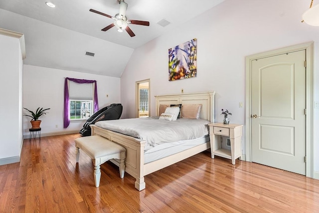 bedroom with light wood-style flooring, visible vents, vaulted ceiling, and baseboards