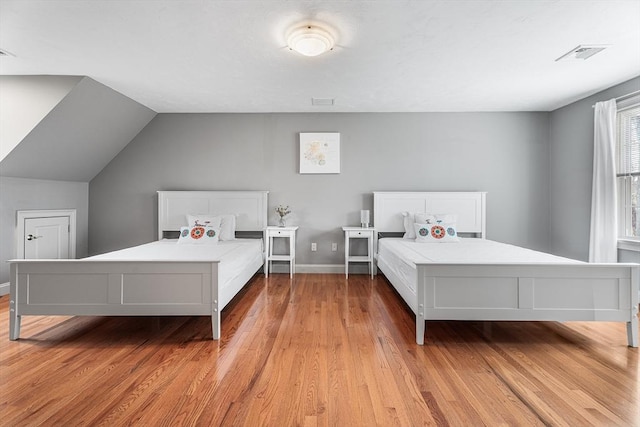 bedroom featuring visible vents, baseboards, and light wood-style floors