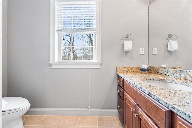 half bathroom with baseboards, toilet, tile patterned flooring, and vanity