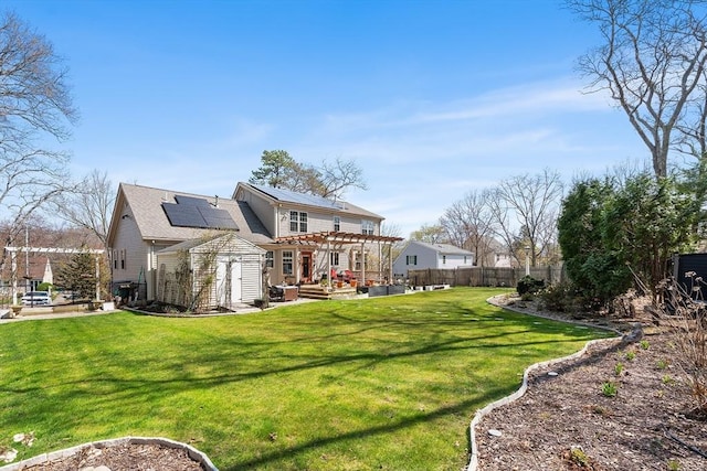back of house with a patio area, a shed, a pergola, solar panels, and a fenced backyard