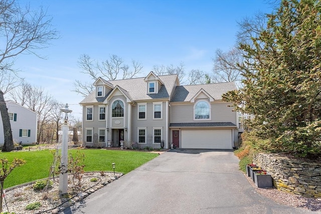 view of front facade featuring driveway, a front yard, and an attached garage