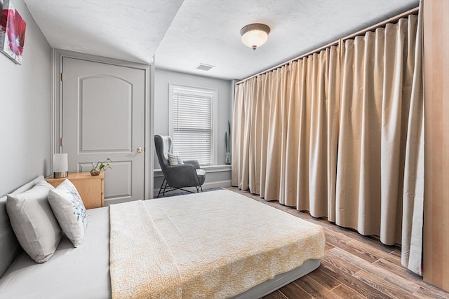 bedroom with visible vents and wood finished floors