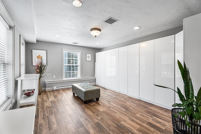 living area featuring recessed lighting, visible vents, and wood finished floors