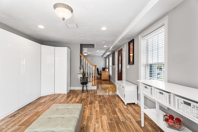 corridor with recessed lighting, visible vents, stairway, and wood finished floors